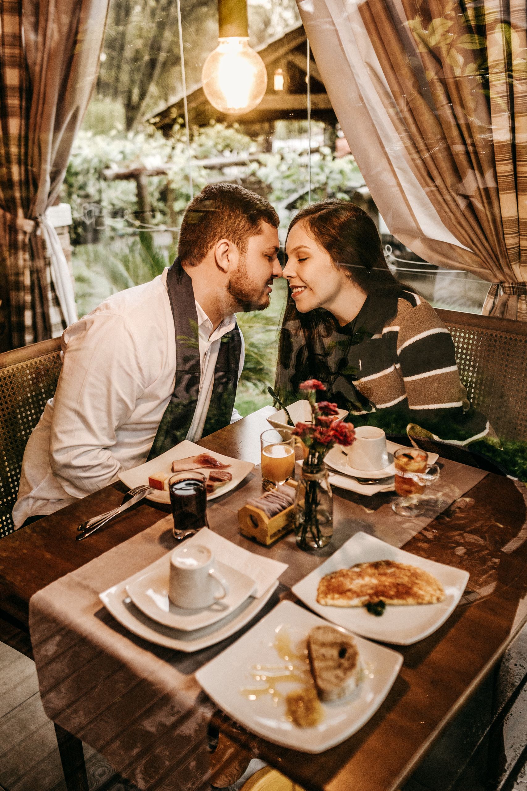 Couple enjoying a romantic dinner with cozy ambiance and delicious food.