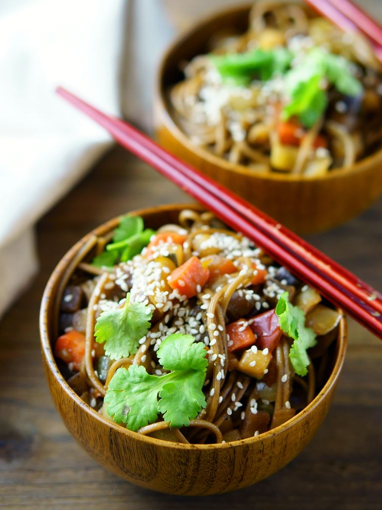 Delicious Asian noodle salad with vegetables, sesame seeds, and cilantro in wooden bowls.