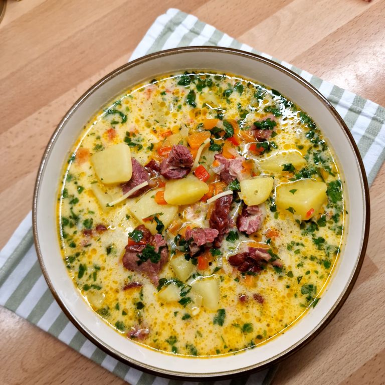 Delicious smoked pork and vegetable soup served in a rustic bowl, perfect for a comforting dinner.