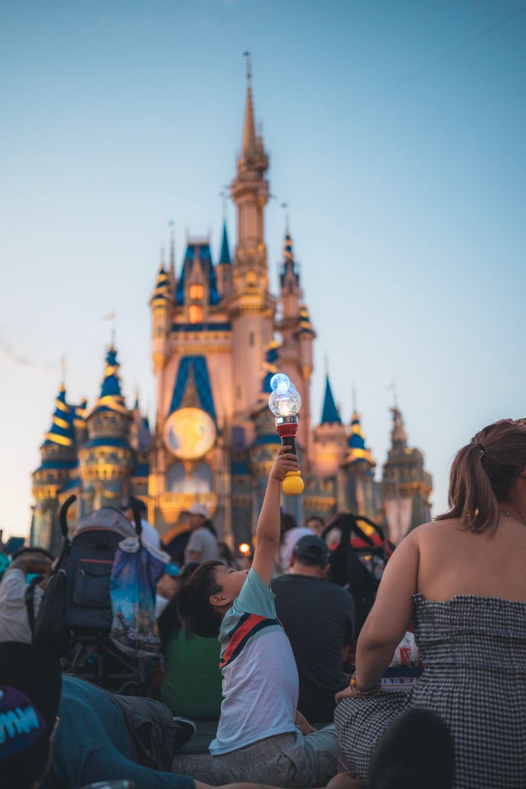 Families enjoy a magical evening at Cinderella Castle, surrounded by iconic architecture and lively entertainment.