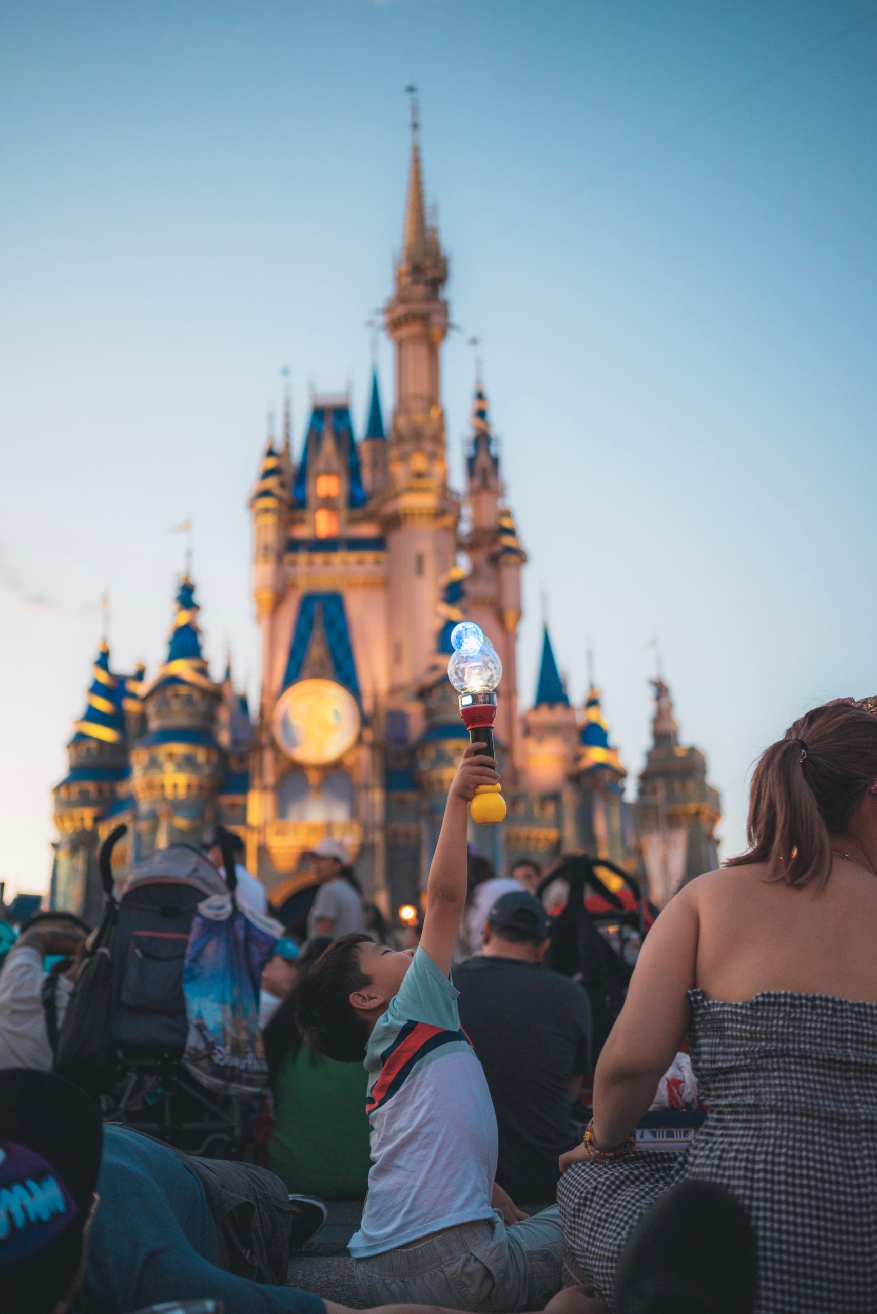 Families enjoy a magical evening at Cinderella Castle, surrounded by iconic architecture and lively entertainment.