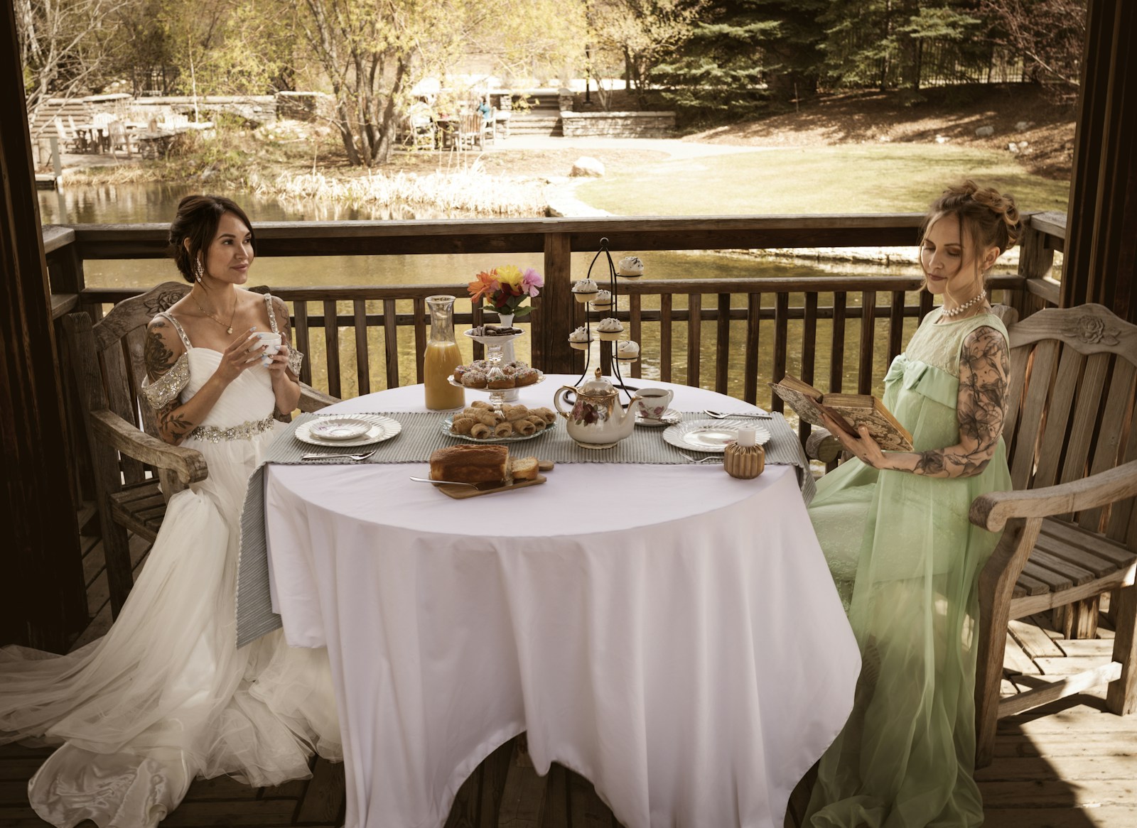 Two women in dresses having tea outdoors