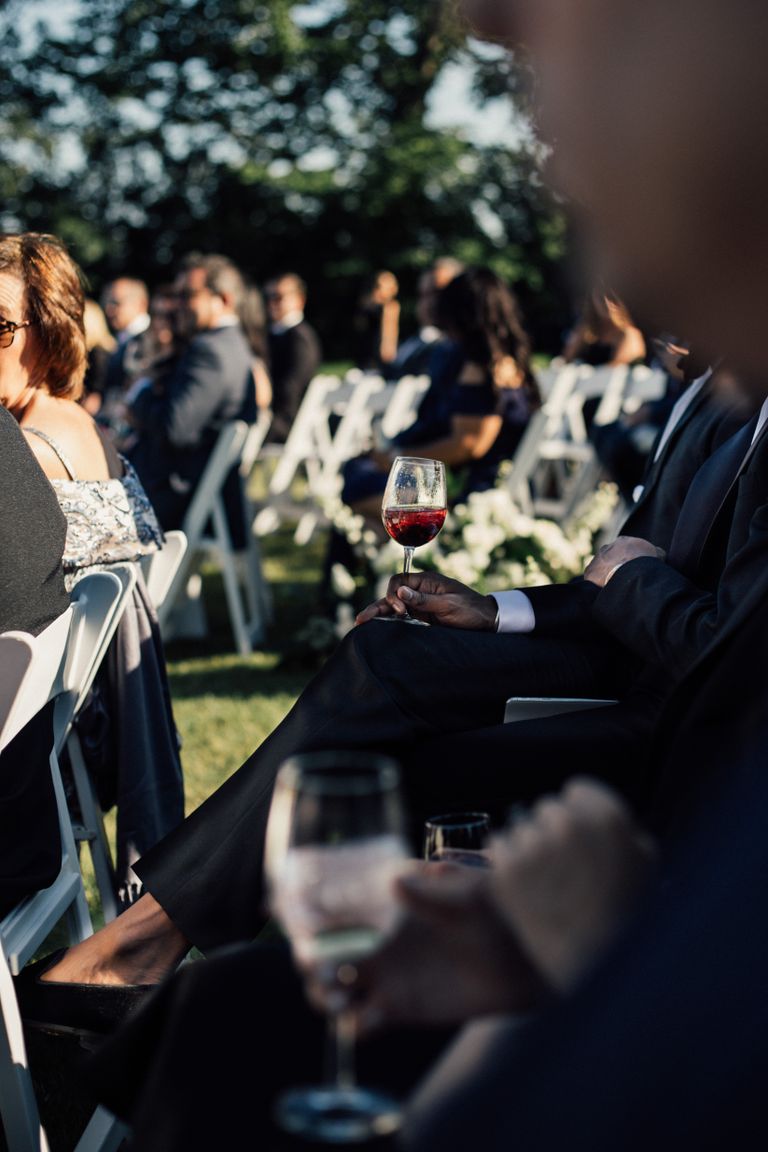 Guests seated with wine glasses during an outdoor wedding ceremony in Newport, RI.