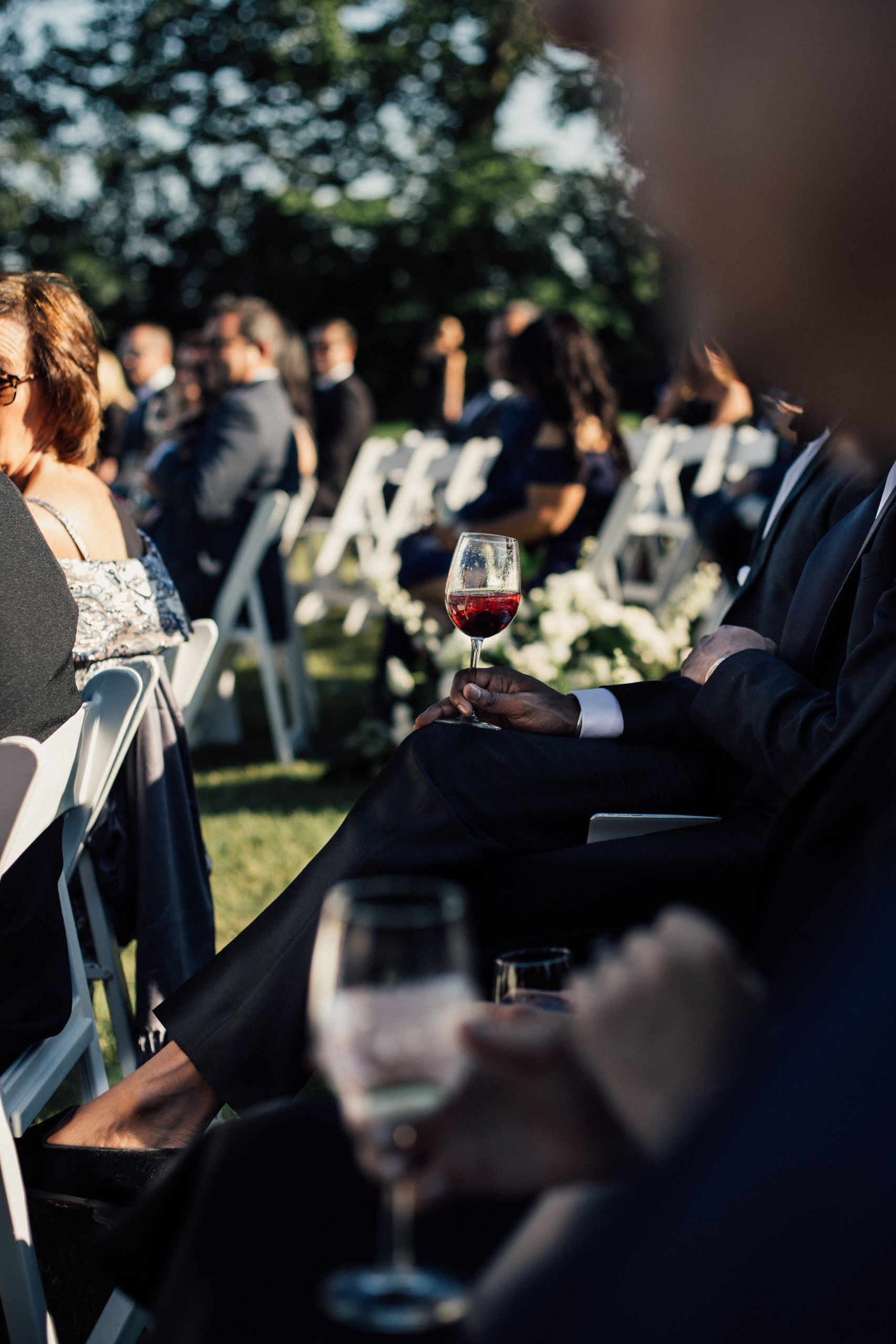 Guests seated with wine glasses during an outdoor wedding ceremony in Newport, RI.