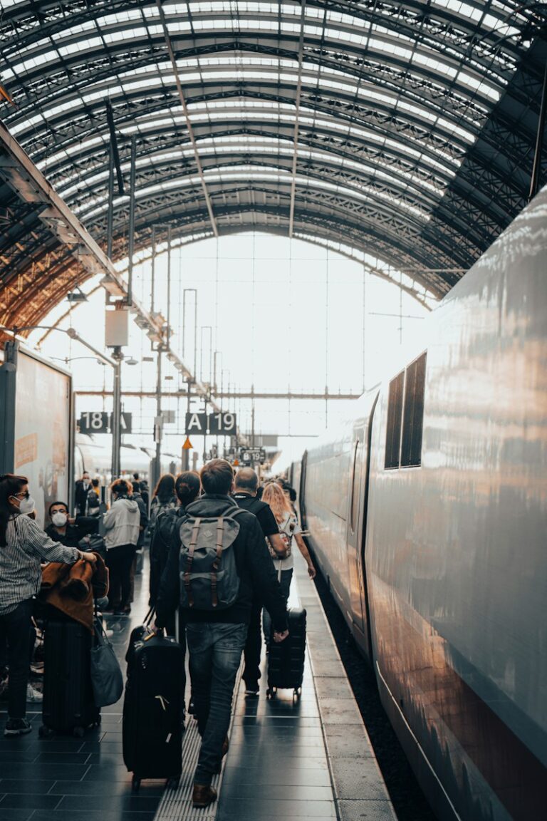 a group of people with luggage walking towards a train