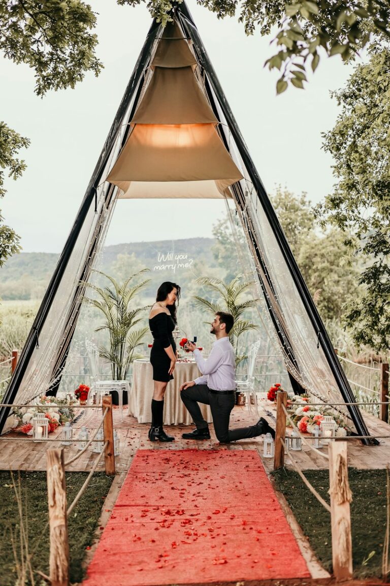 a man and woman sitting at a table in front of a tent