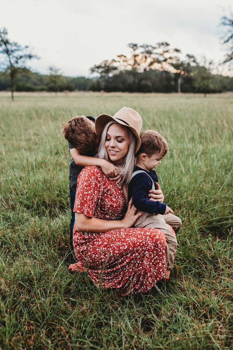 man and two children on grass field