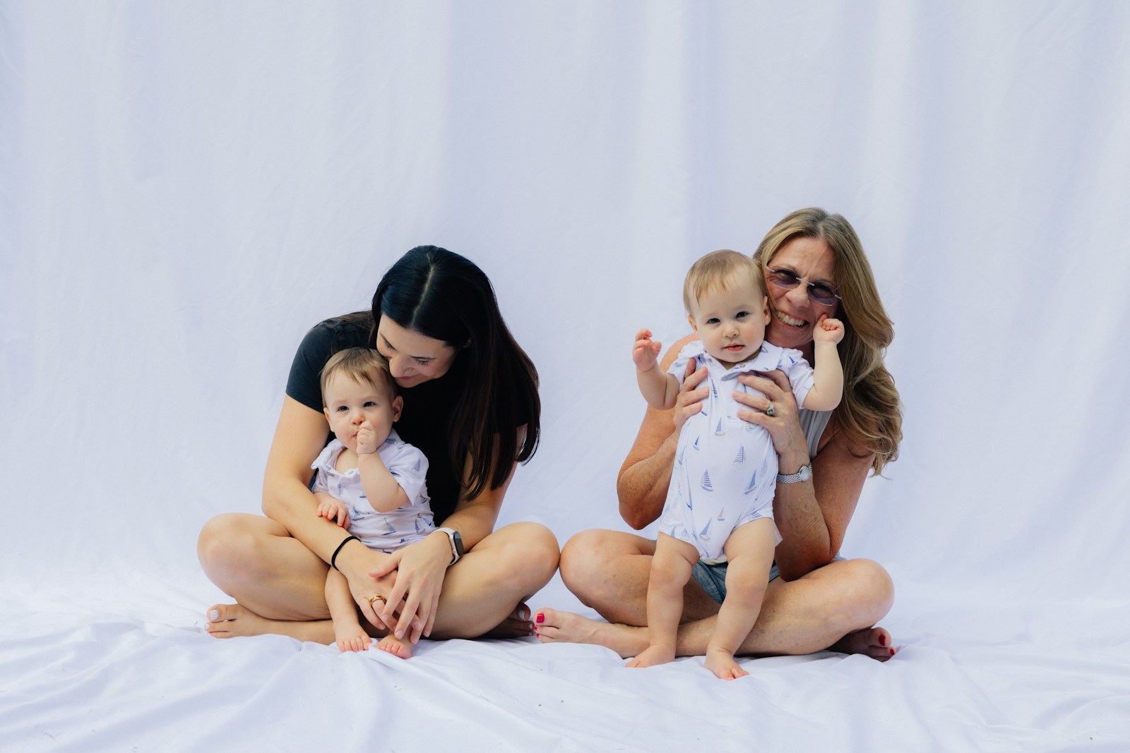 Two women holding babies on white background