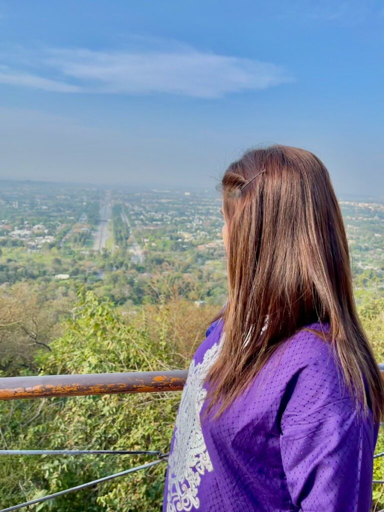Woman in purple looking over a green valley