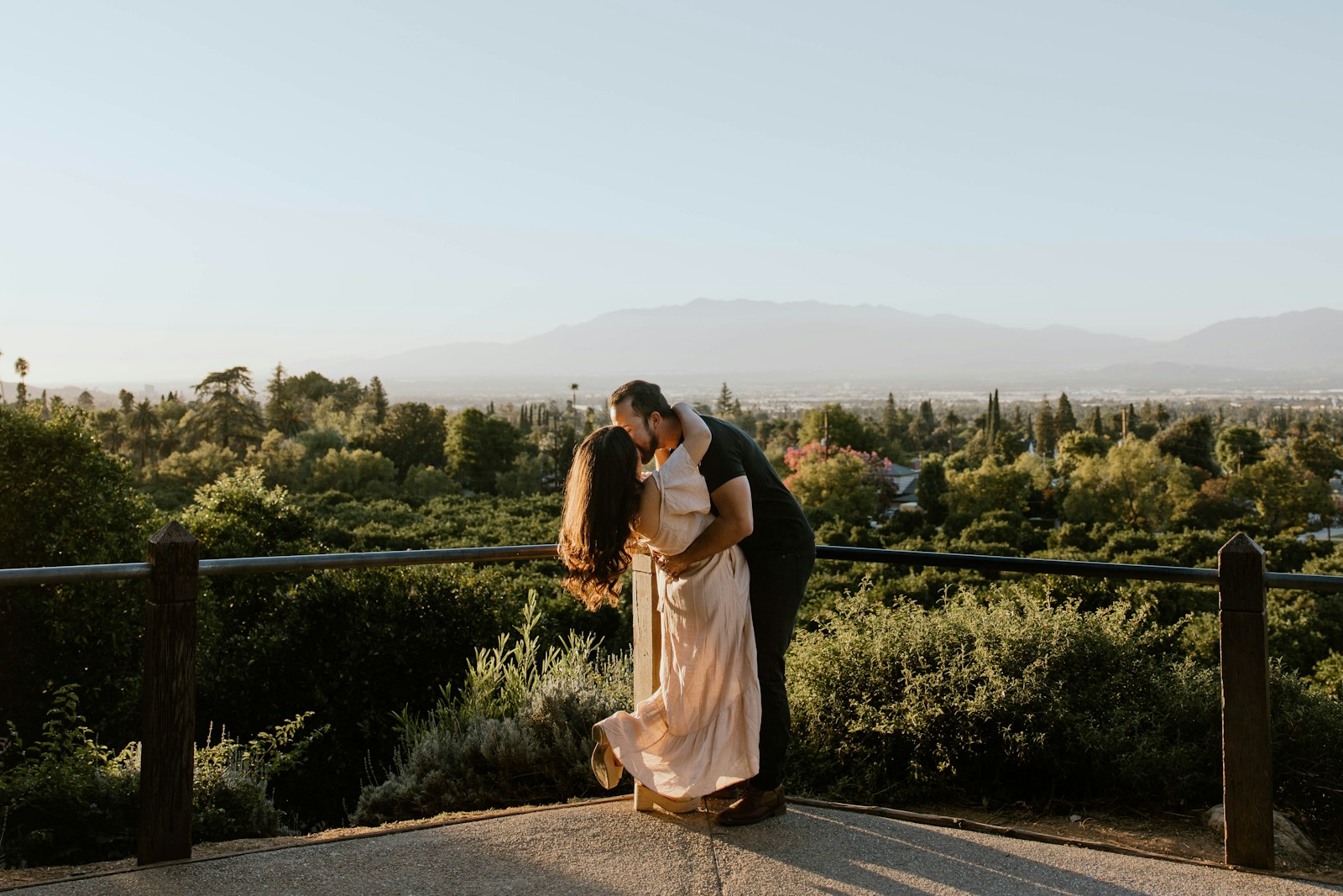 a man and a woman kissing on a balcony