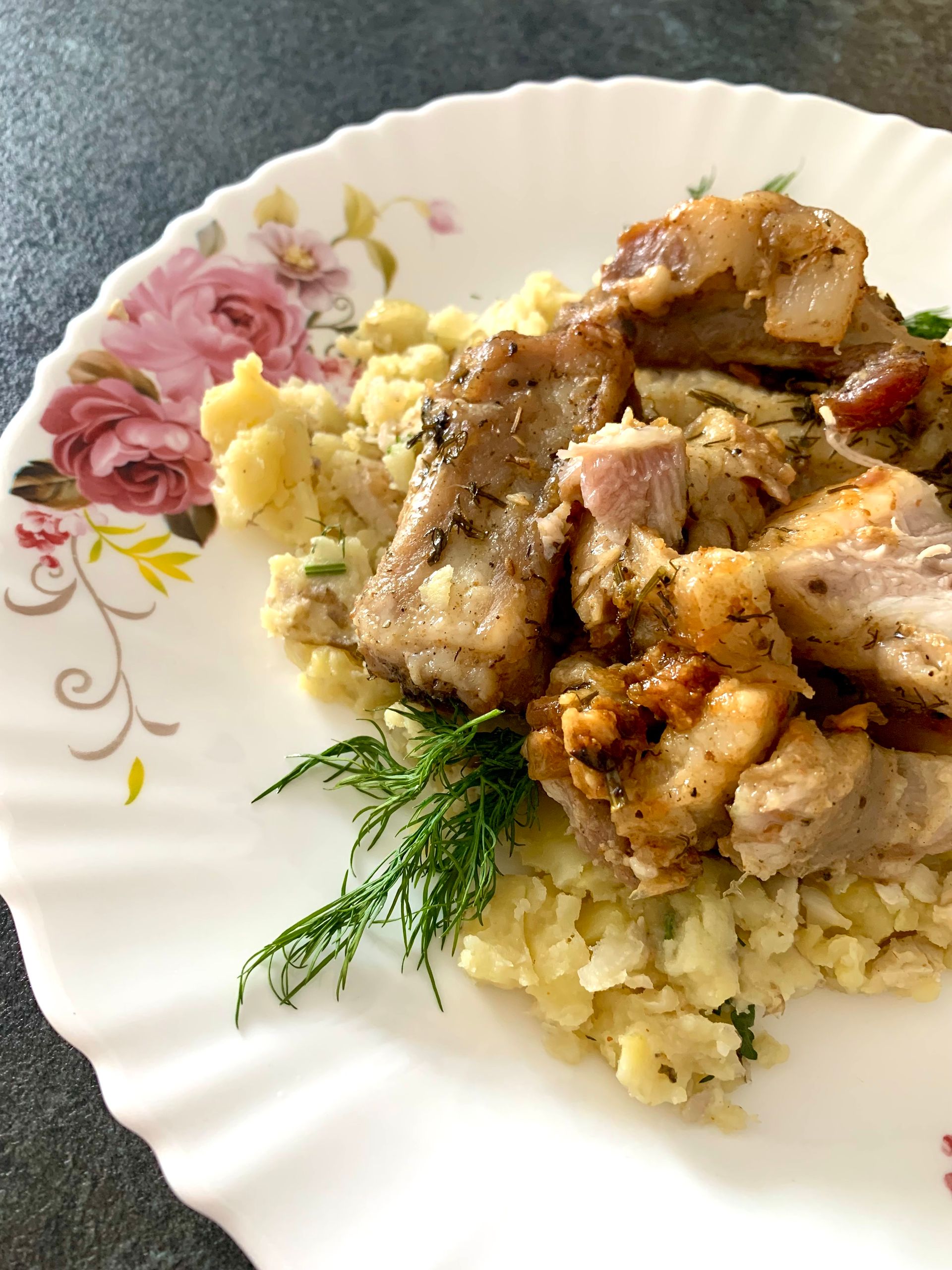 Savory grilled pork served with creamy mashed potatoes on a floral plate