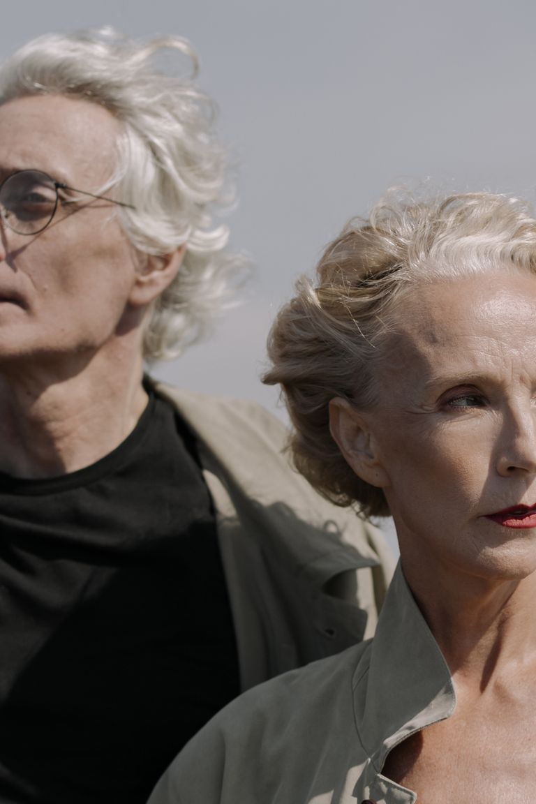 Stylish gray-haired couple looking into the distance, capturing elegance and maturity.