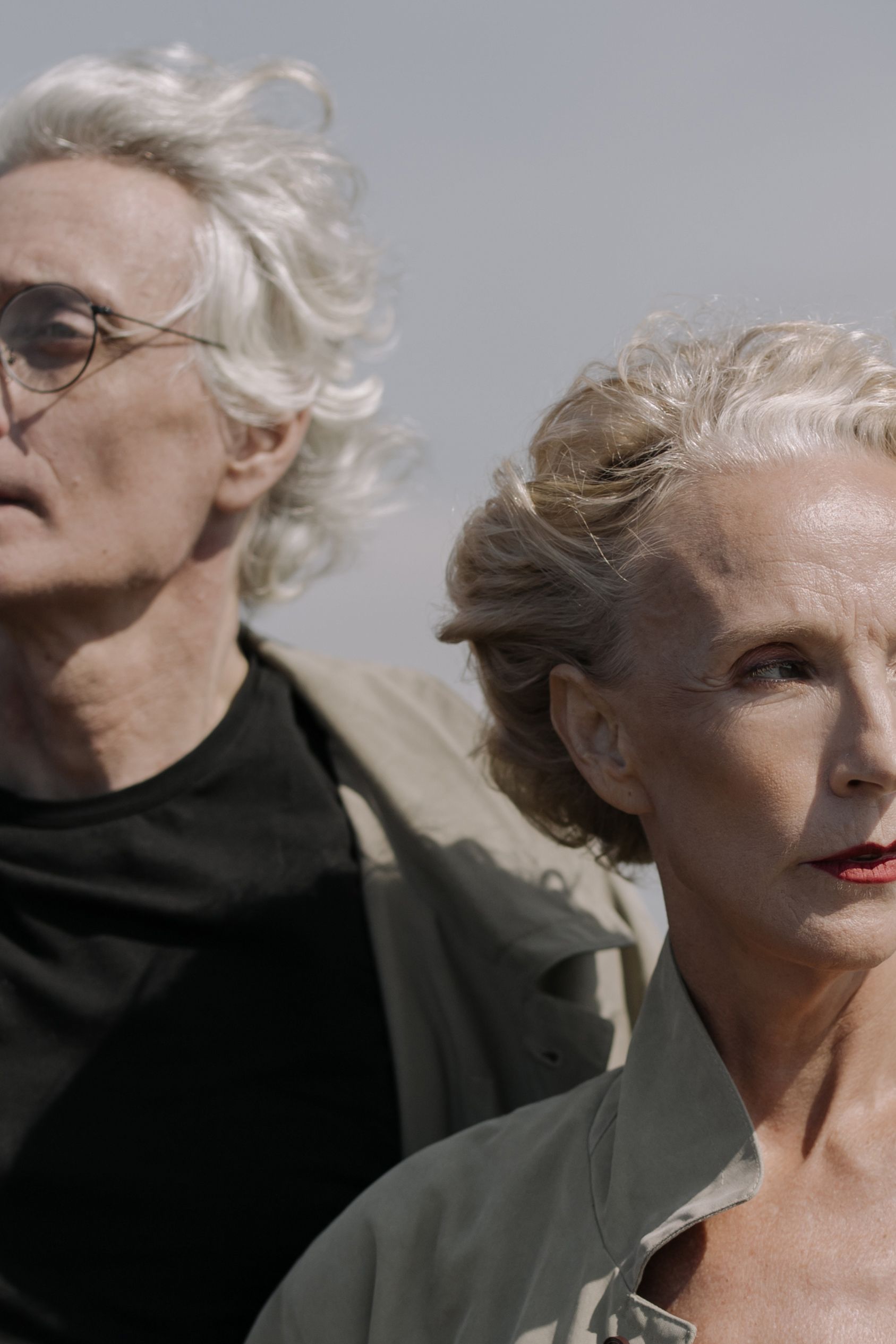 Stylish gray-haired couple looking into the distance, capturing elegance and maturity.