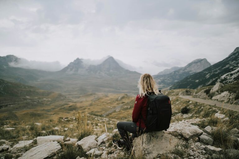 a man sitting on a rock overlooking a valley