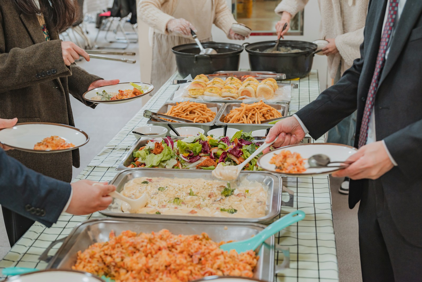 People serving themselves food at a buffet