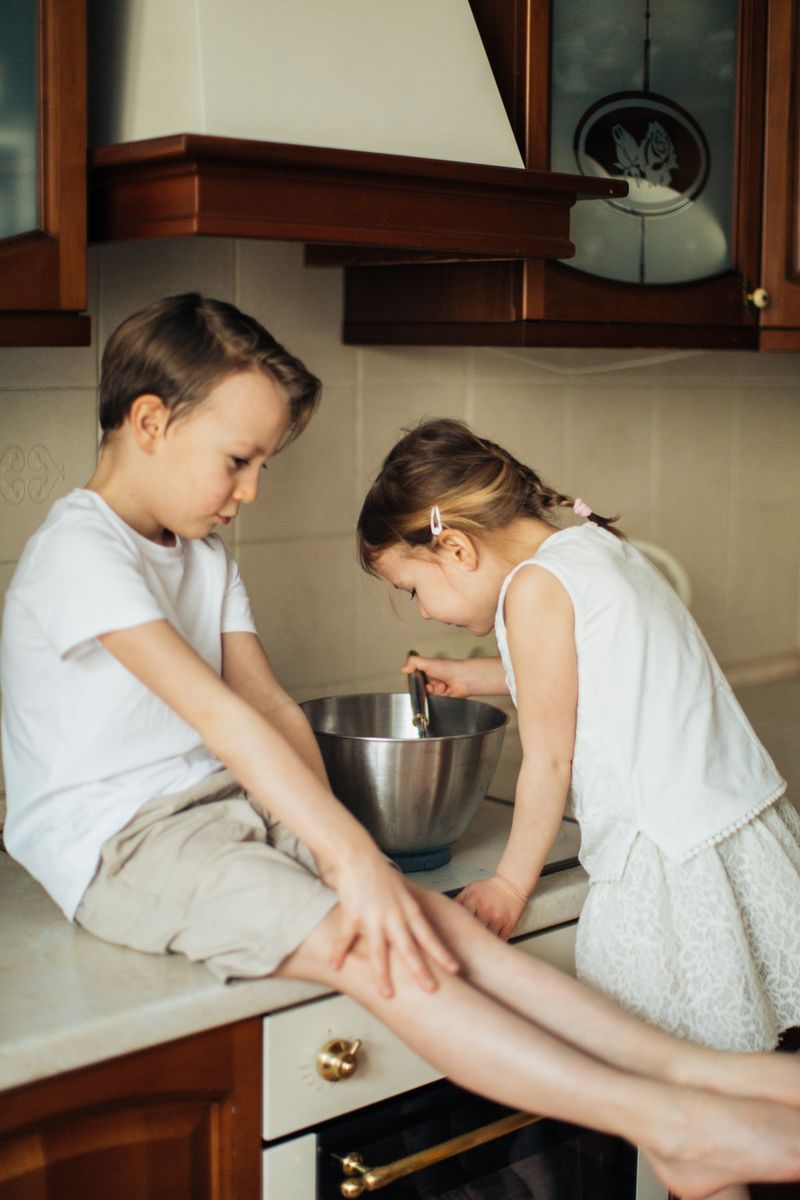 Two kids enjoying baking activities in the kitchen, fostering creativity and fun.