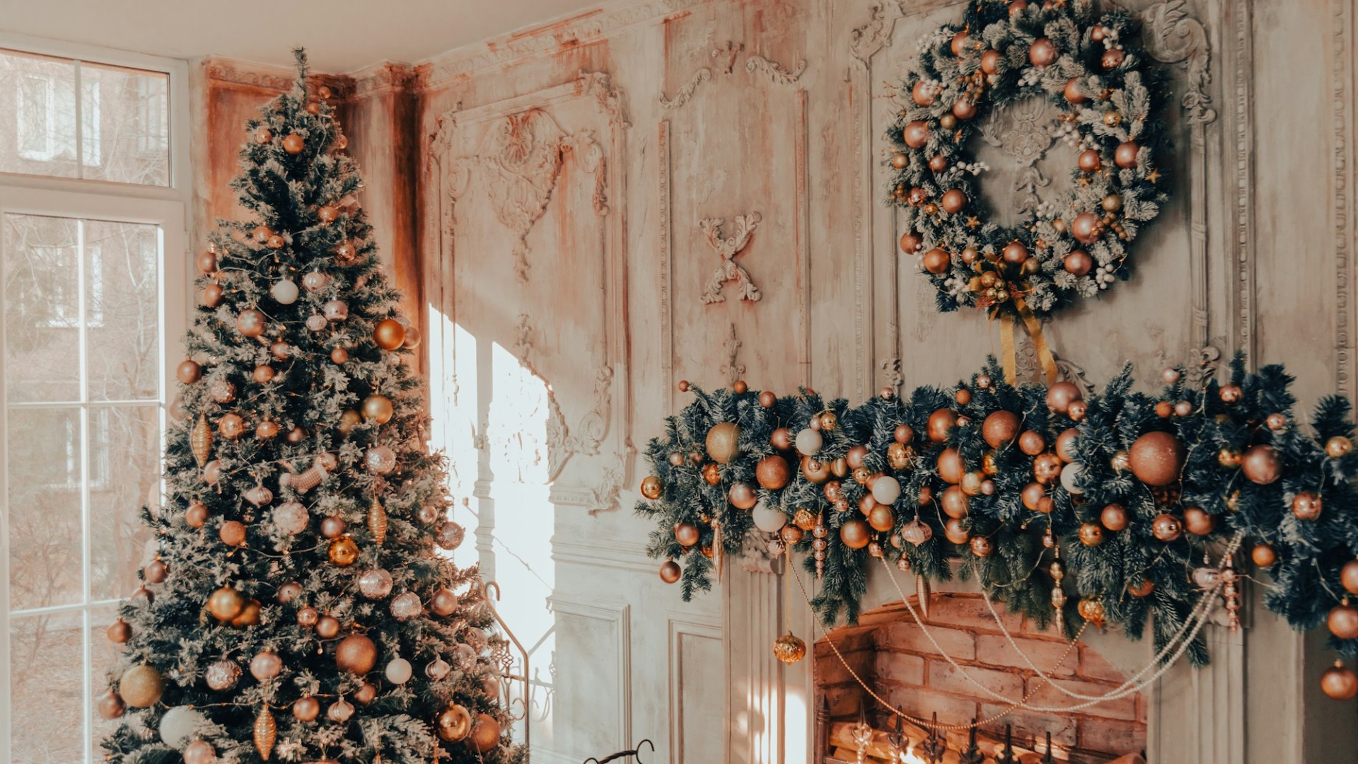 A Christmas tree and wreaths beside a fireplace. Photo by Collab Media on Unsplash.