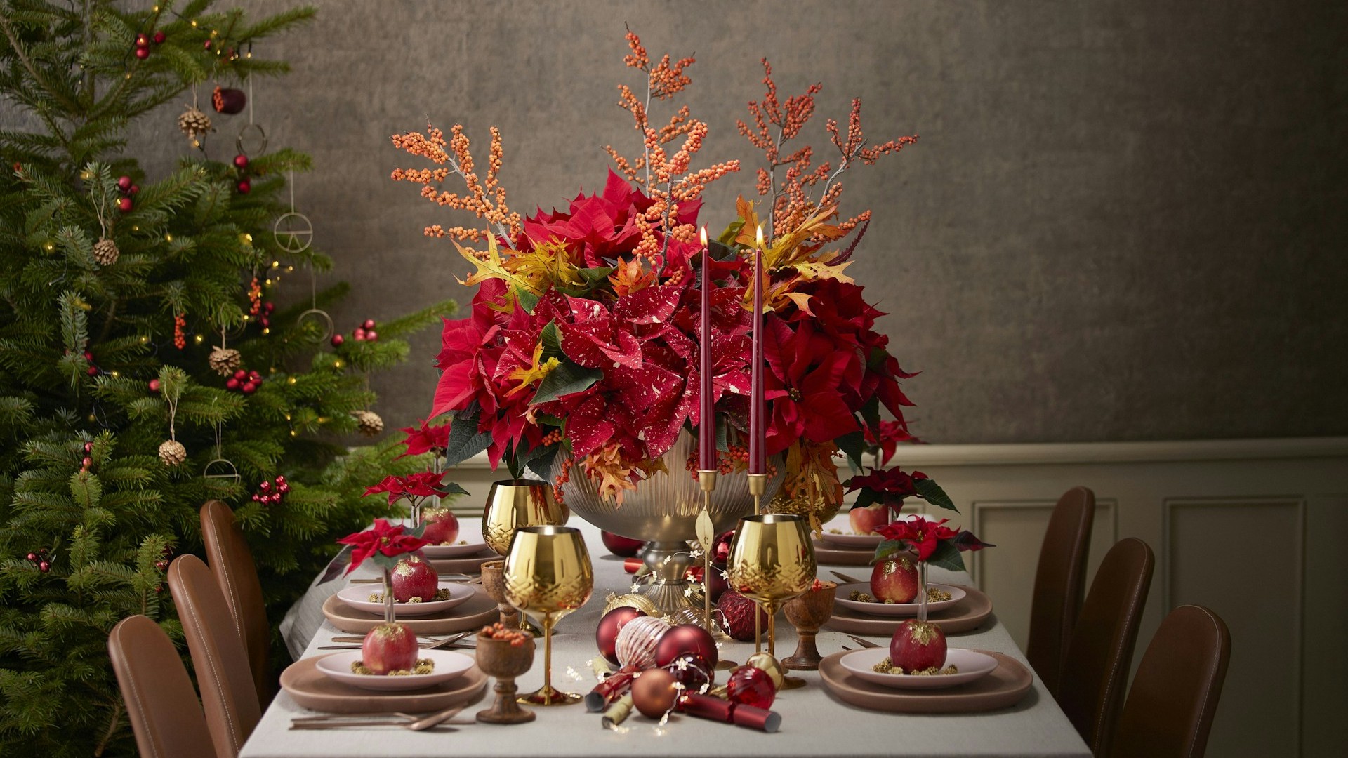 Unsplash photo by Shayla Bruins showing a Christmas dinner table with a white tablecloth and red poinsettia centerpiece