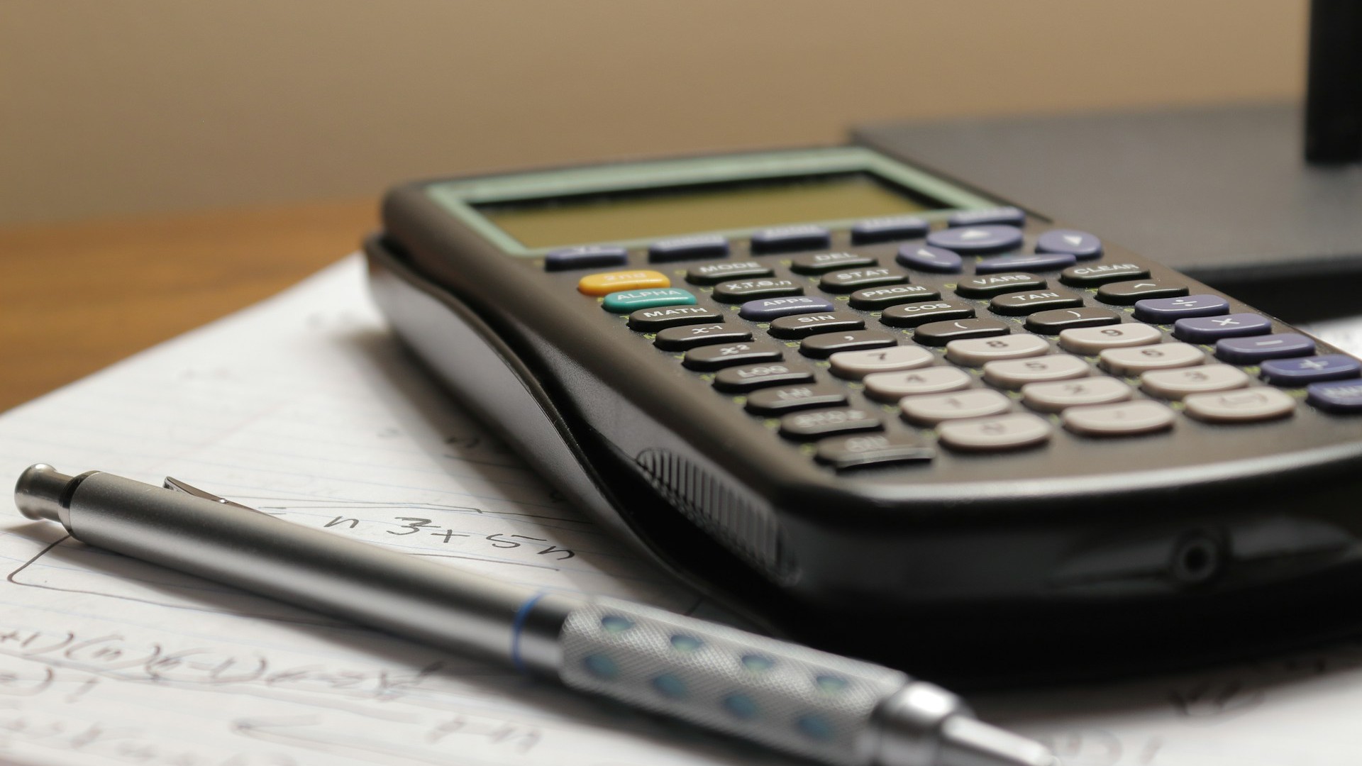 Unsplash photo by Aaron Lefler showing a calculator and pen on a sheet of paper