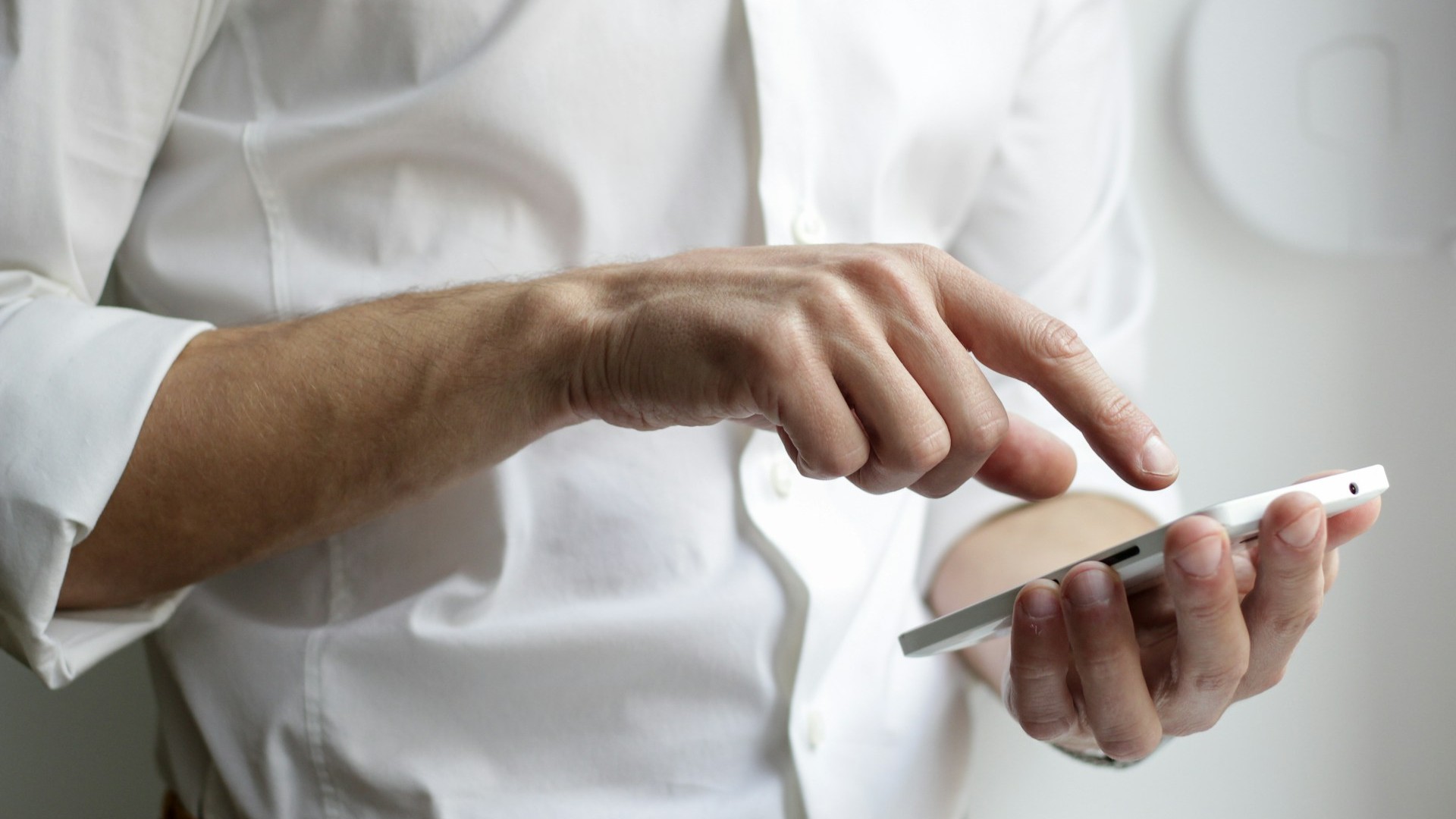 Unsplash photo by NordWood Themes showing hands holding a white smartphone