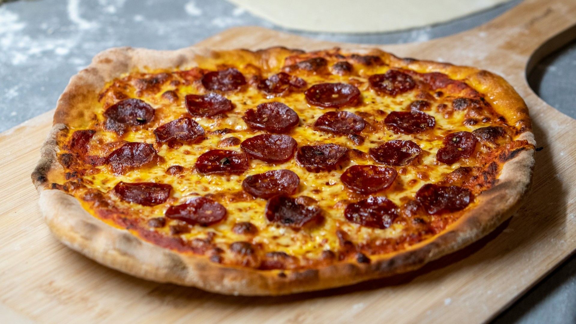 Unsplash photo by amirali mirhashemian showing a pepperoni pizza on a wooden tray