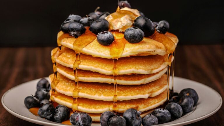 Unsplash photo by Amber Fisher showing a stack of pancakes topped with blueberries and syrup