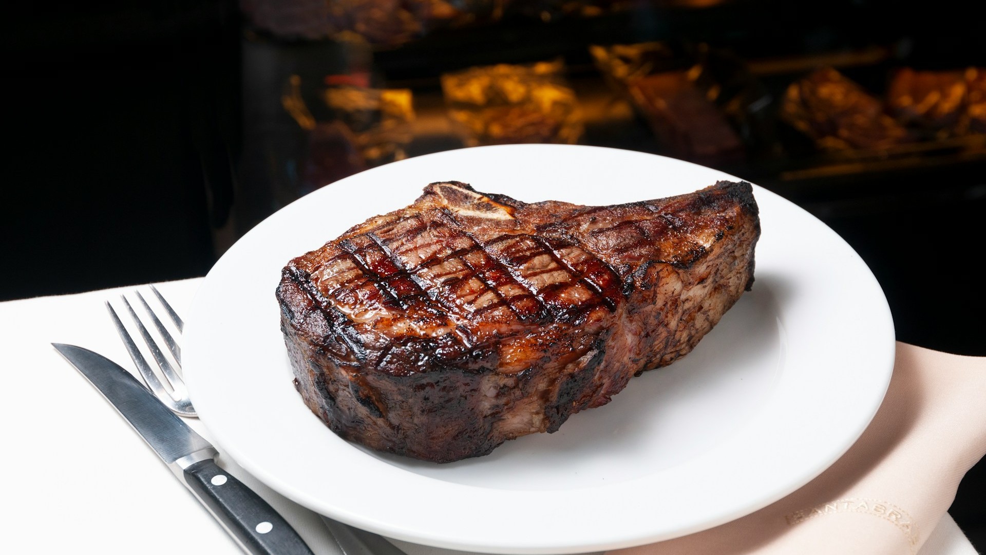 Unsplash photo by Marcelo de la Torre showing a steak on a plate with a fork and knife