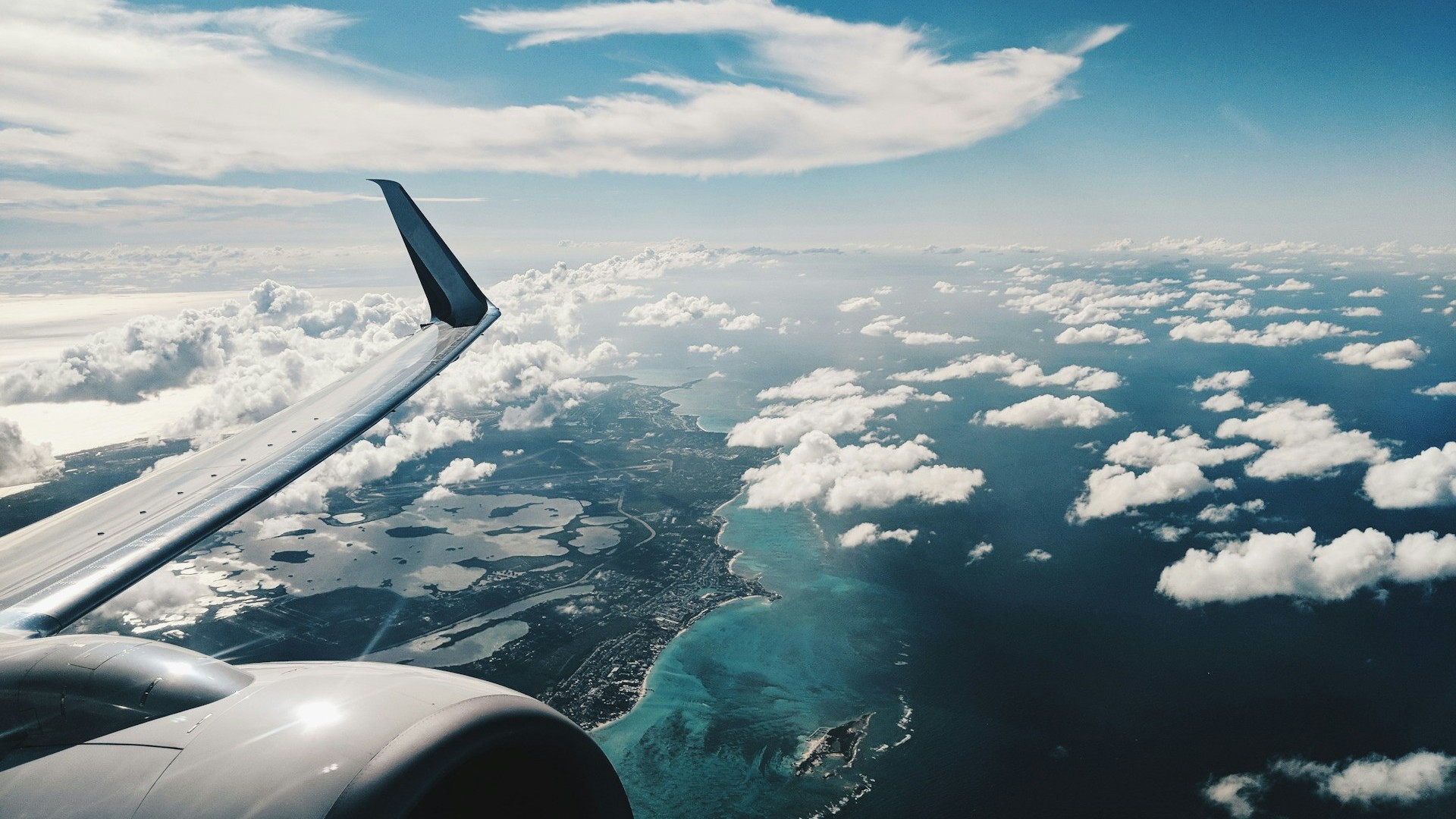 Unsplash photo by Patrick Tomasso showing an airplane wing against a blue sky in daytime