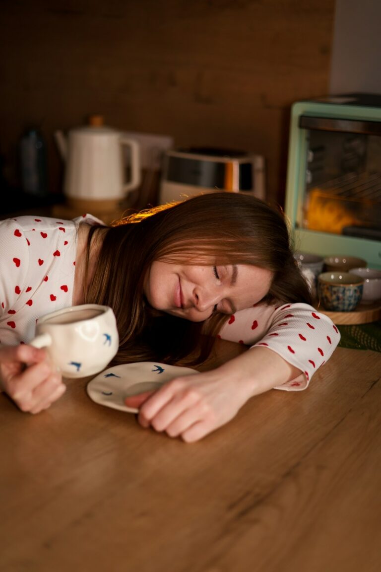 A tired woman rests with coffee at the table